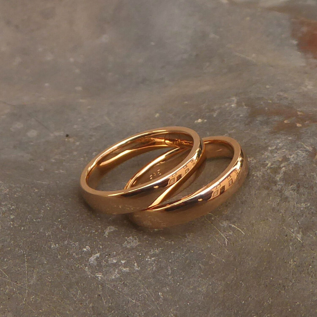 ein-paar-trauringe-in-gelbgold-aus-den-eheringen-der-grosseltern-angefertigt-eine-tolle-moeglichkeit-zum-upcycling-und-echter-schmuck-mit-bedeutung-die-ringe-haben-eine-klassische-form-innen-und-aussen-abgerundet-und-eine-seitenkante-oberflaeche-poliert