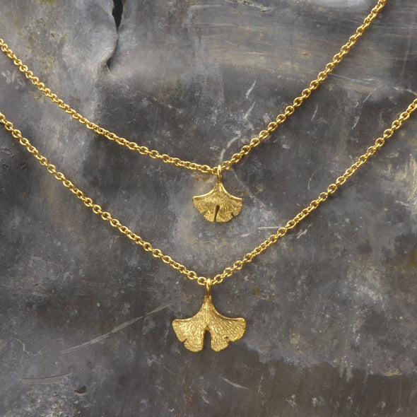 zwei-handgefertigte-ginkgo-anhaenger-in-verschiedenen-groessen-an-zarter-ankerkette-in-silber-vergoldet-oder-echtgold-aus-unserer-goldschmiede-in-frankfurt-auch-in-fairtrade-gold-erhaeltlich